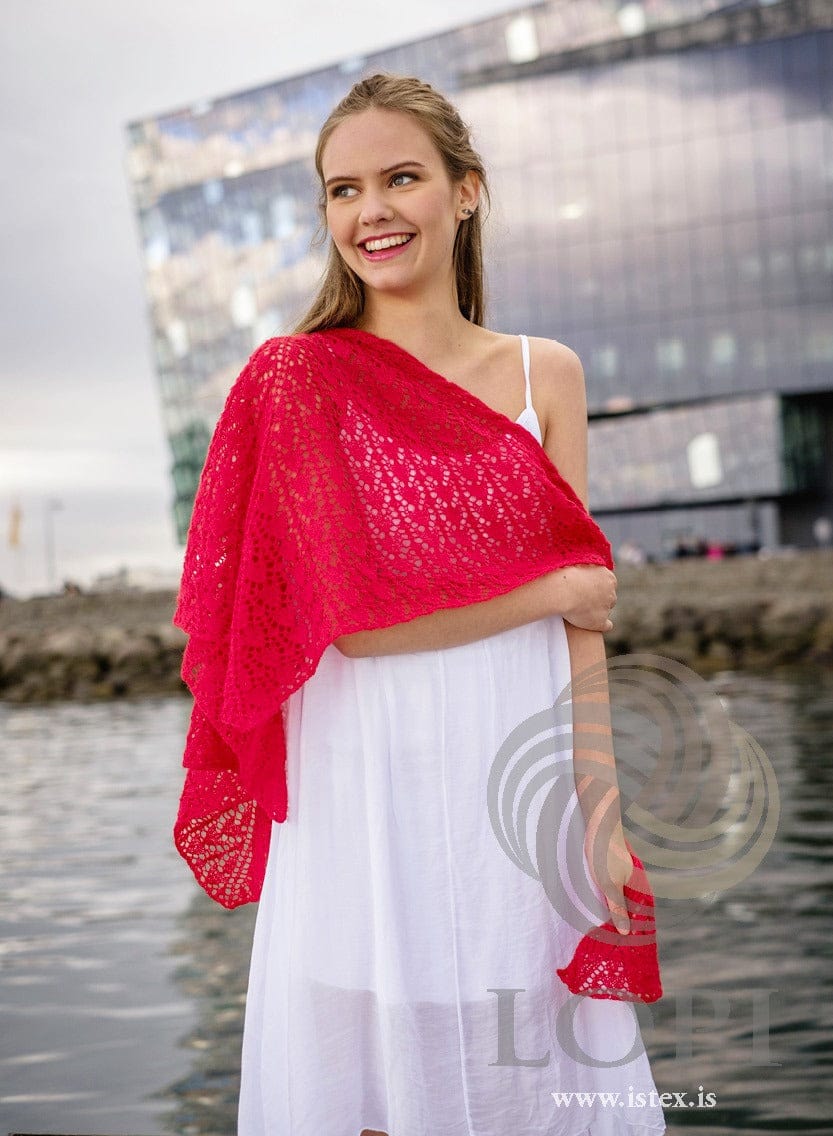 Túlipanar lace cape in flame red Einband, worn over a white dress