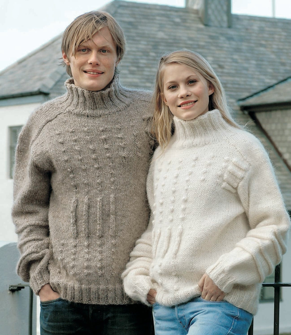 Man in the light beige heather Tattó turtleneck, with columns of bobbles and raised vertical strips on the front; the woman wears Tattó in white