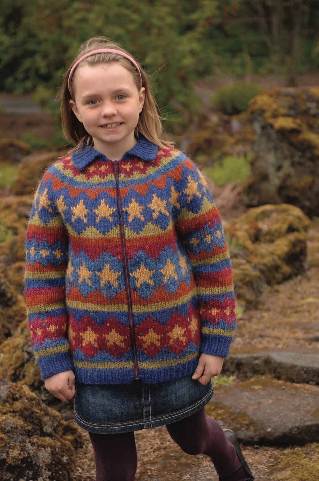 The same Stjörnur pattern in its first colourway, on a girl — golden stars in blue and red diamonds — sold as a separate kit (shown in its original colours; that kit has replacement colours). The skirt, headband, tights and shoes are not part of the pattern
