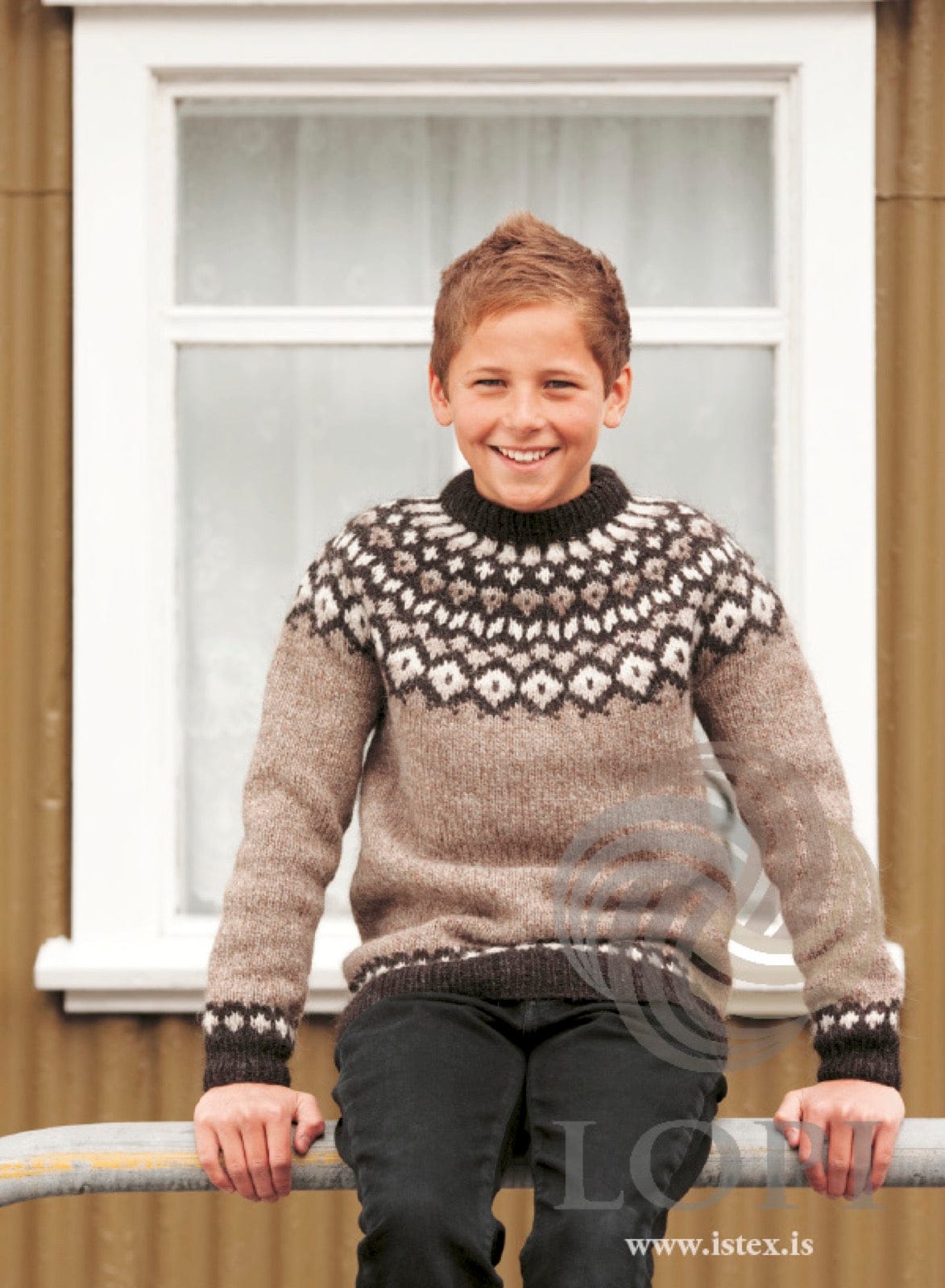 Boy in the beige Verur sweater — oatmeal Léttlopi with a dark brown yoke and bands patterned in white and light beige, and a dark folded neckband