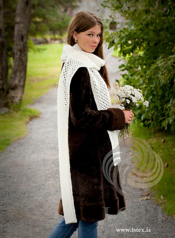 Woman wearing the Blúndutrefill — a long white Einband lace scarf wrapped once round the neck, the ends hanging long