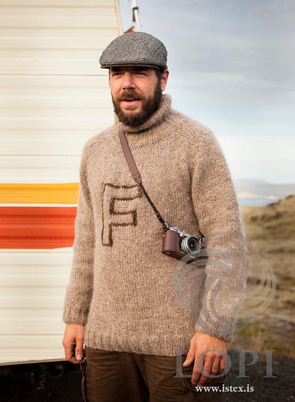 Man in the Frikki sweater — oatmeal heather Álafosslopi with a tall ribbed collar and a chocolate F on the chest