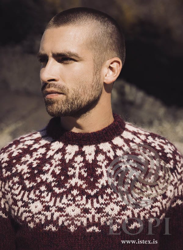Close view of the Aðventa yoke pattern in ivory beige and white on deep red