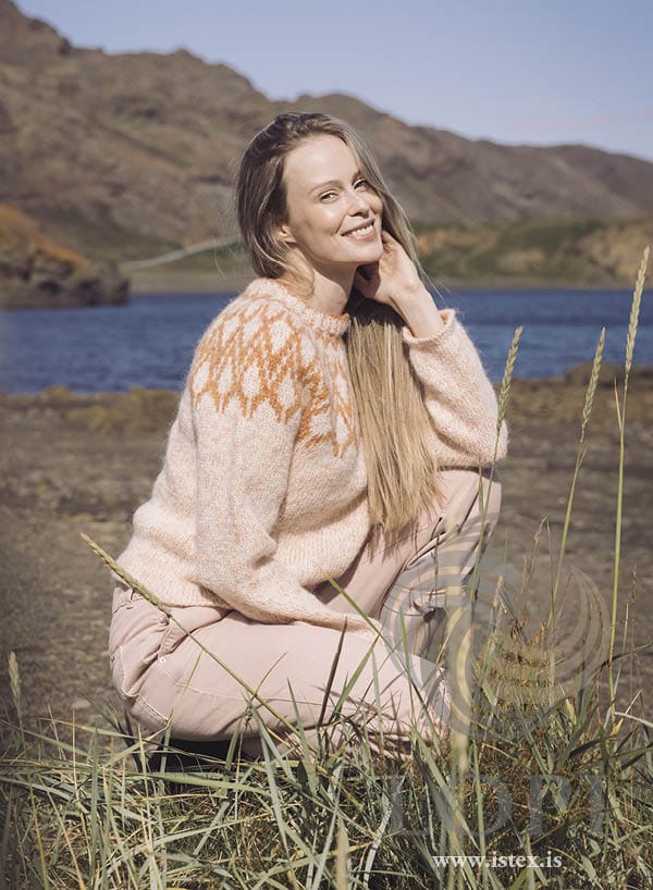 Mar yoke sweater in blush Plötulopi and Einband, seated by the sea