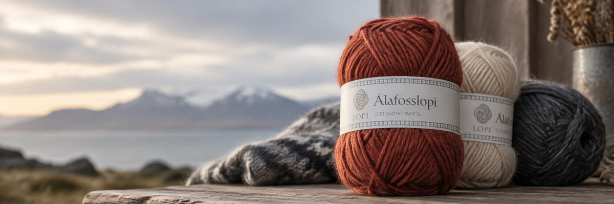 Álafosslopi yarn balls on a wooden table with Icelandic mountains behind