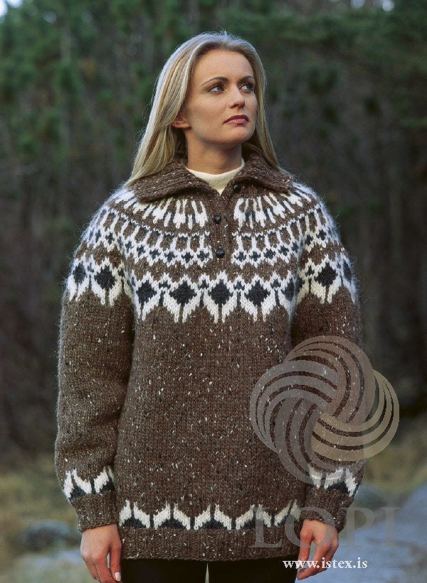 Woman in the Lopi 18 no. 17 sweater — brown with a yoke of black heather diamonds framed in white, a short opening with three buttons and a folded rib collar, and a border above the hem and cuffs; the cream polo neck under it is not part of the pattern (shown in the original colours — this kit has acorn heather, a close brown without the tweed flecks, for the medium brown tweed)