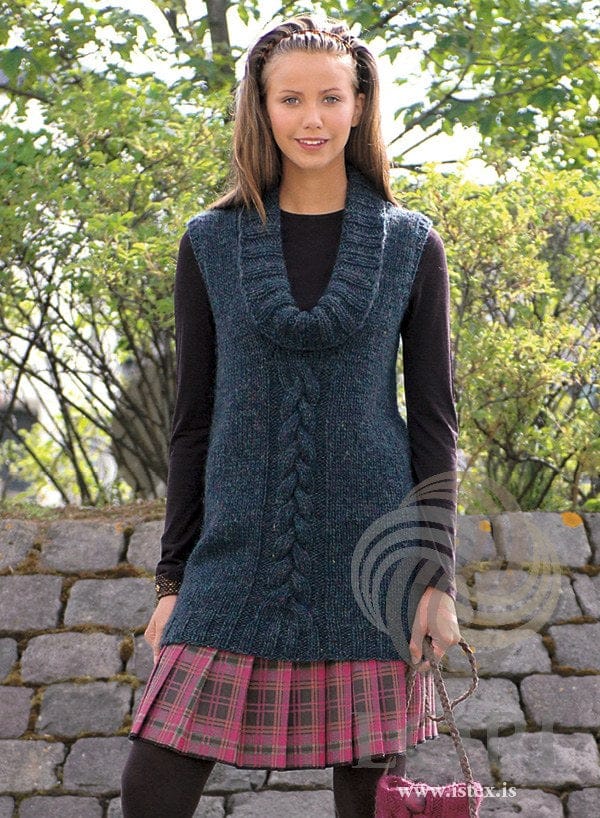 Woman in the U tunic — long and sleeveless, with a braided cable up the front and a deep rib cowl collar (shown in the original colour, pond heather — this kit has teal heather). The black top, skirt, tights and pink bag are not part of the pattern