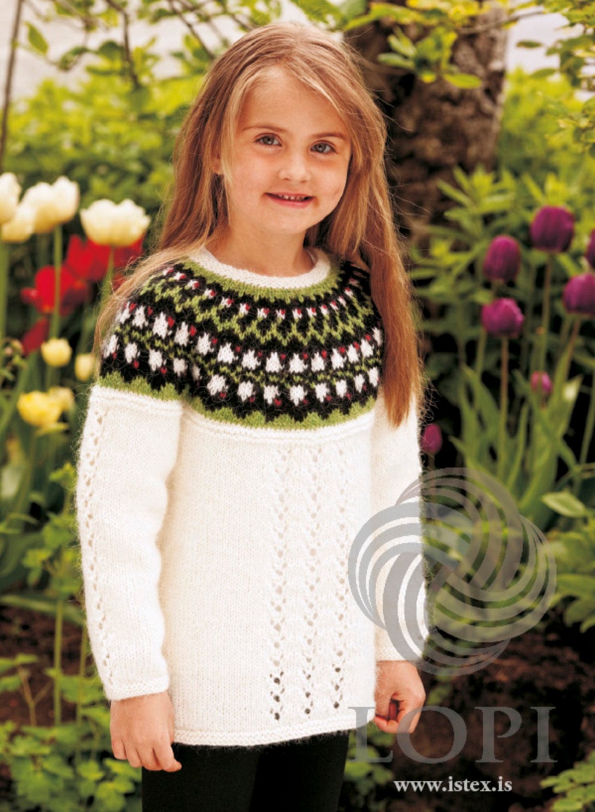 Girl in the white Bláklukka sweater — white Léttlopi with eyelet panels and a black yoke band of white bell flowers, crimson dots and green zigzags