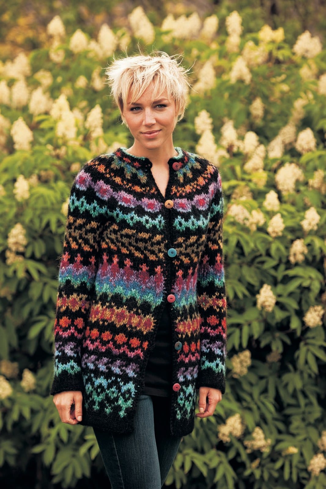 The same Endurreisn jacket in its colourful version — black with bright bands in teal, blues, lilac, violet, pink, red, orange and gold — sold as a separate kit (shown in its original colours; that kit has five colours replaced). The coloured buttons are not included; the black top and the jeans are not part of the pattern