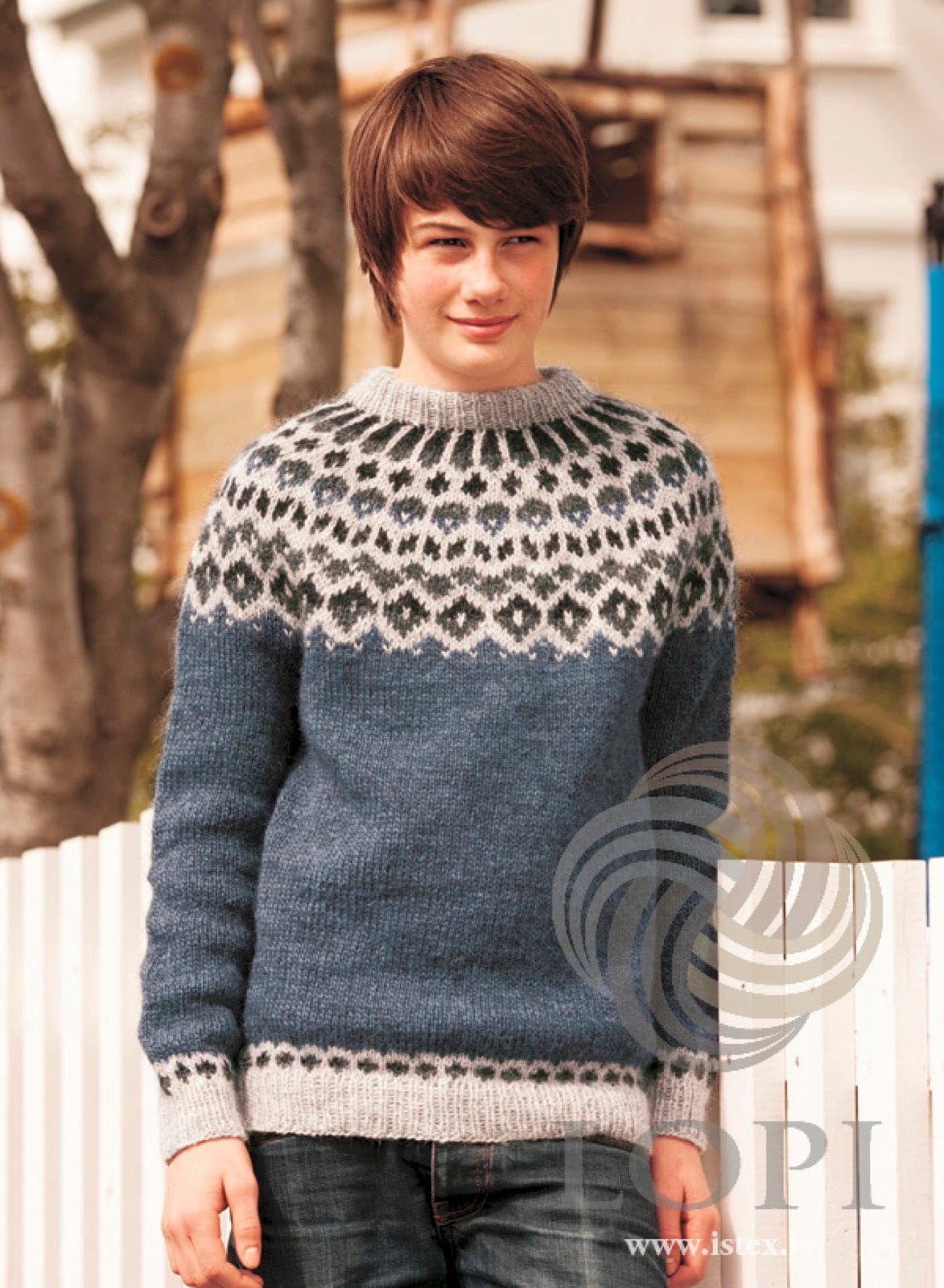 Teenager in the blue Verur sweater — stone blue Léttlopi with a light grey yoke and bands patterned in dark grey-green and black, and a light grey folded neckband