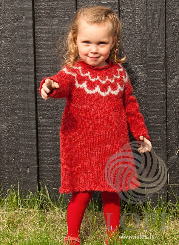 Little girl in the Bára dress — carmine red Plötulopi with a light ash yoke pattern and shell edging