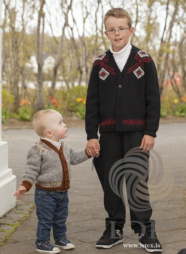 The older boy in the black Norður cardigan, holding the hand of a toddler in the grey version — sold as a separate kit