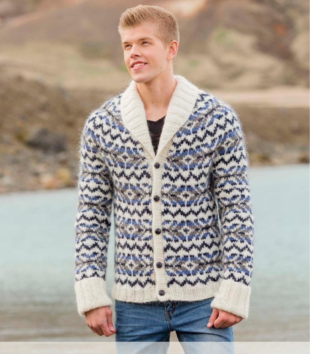 Man in the Rökkur cardigan — white Álafosslopi with midnight blue, denim and grey zigzags, a ribbed shawl collar and folded white cuffs