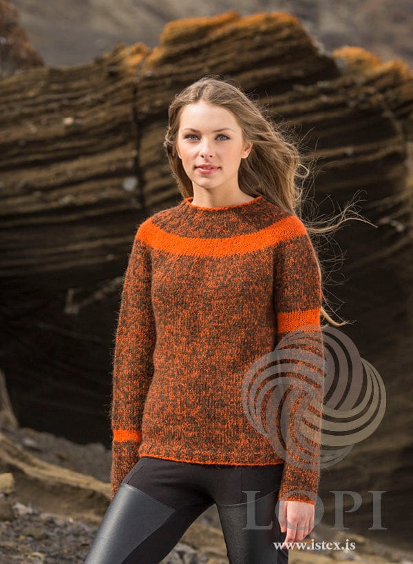 Woman in the Slydda sweater — rust-brown tweed of orange Einband and chocolate Plötulopi, with orange stripes on the yoke and sleeves