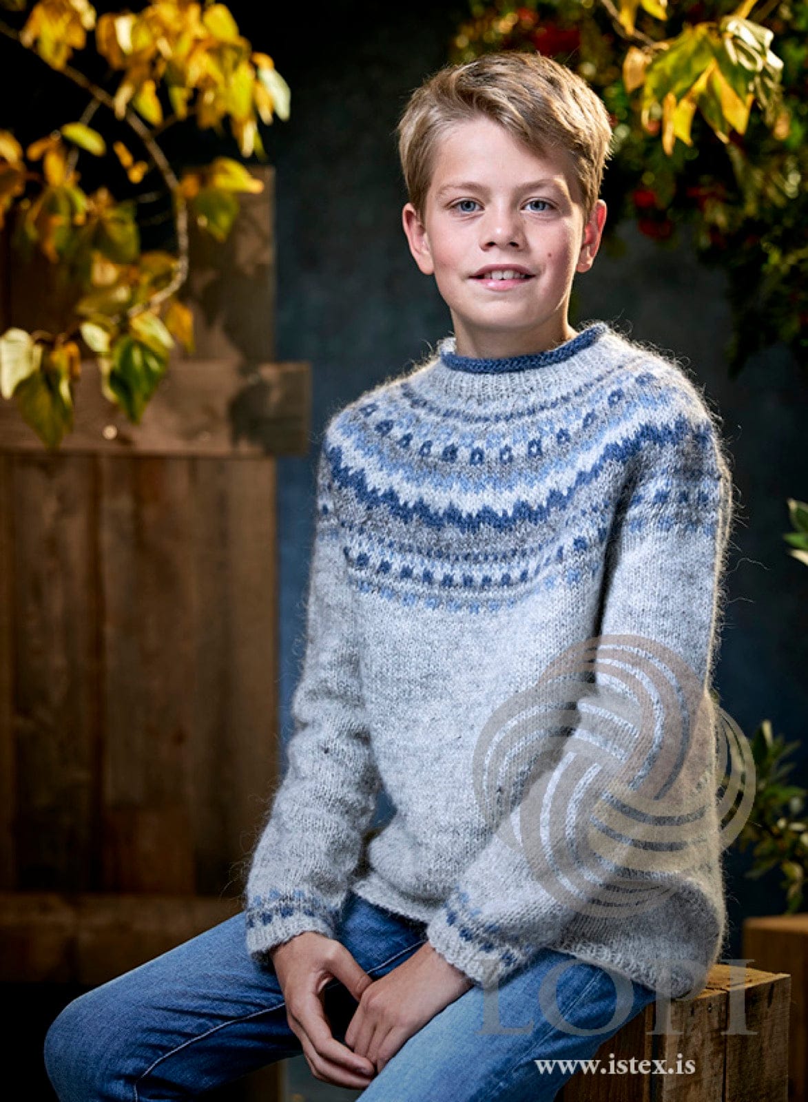 Boy in the Mistur sweater — light ash heather Léttlopi with a yoke and cuff bands in air blue, fjord blue and ash heather, and a rolled blue neck edge