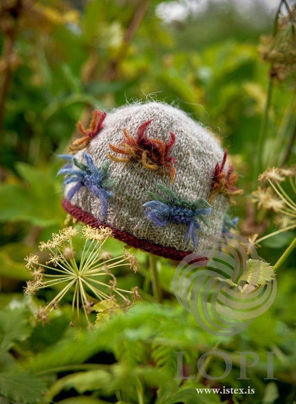 Lausn light hat with tufts in blue, green and rust and a rolled brick brim