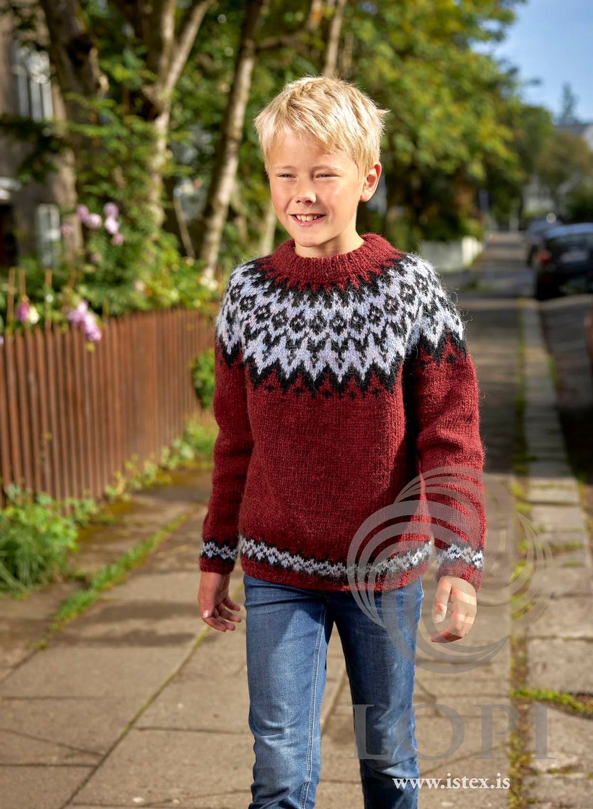 Neisti children’s yoke sweater knitted in Léttlopi — brick red with a black and milkyway yoke and borders