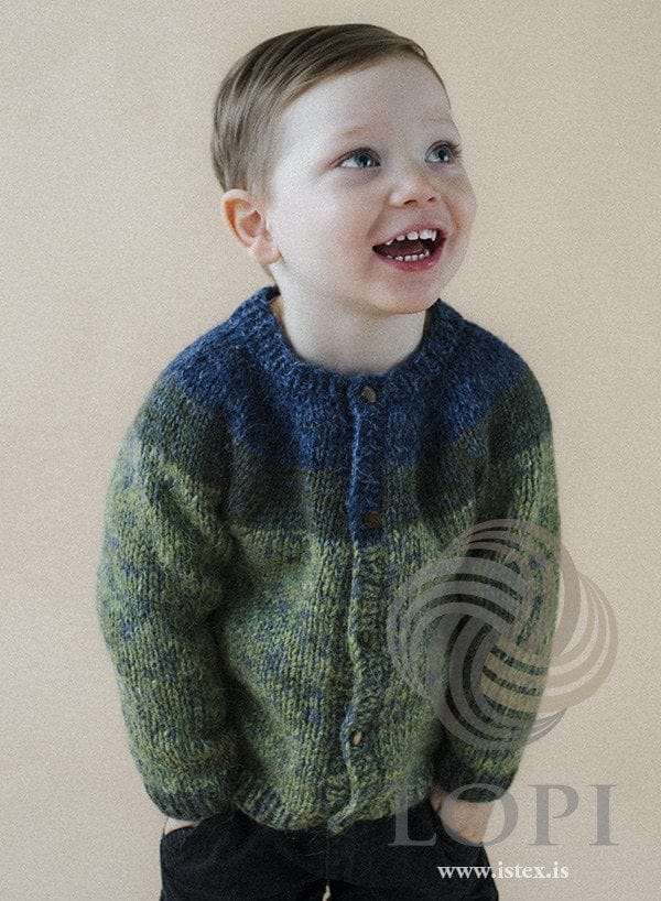 Laughing boy in the green-blue Geisli cardigan — winter blue collar and upper yoke, a spruce green band and a clover green body, buttoned