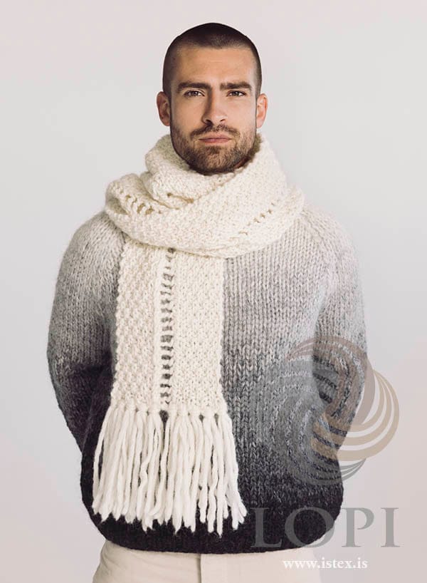 Stigi scarf in white Jöklalopi with fringes, worn over a grey sweater