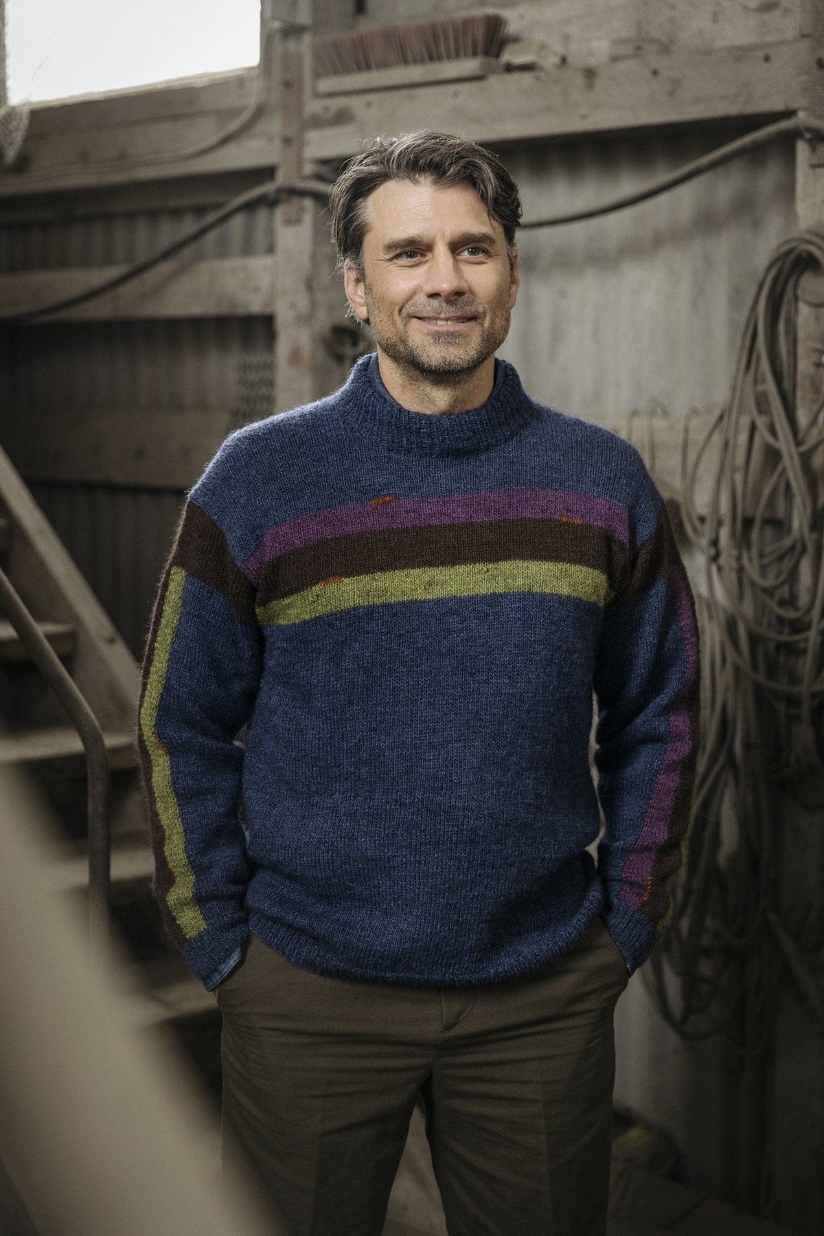 Kilir sweater worn — colour bands across the chest and a stripe down the sleeve
