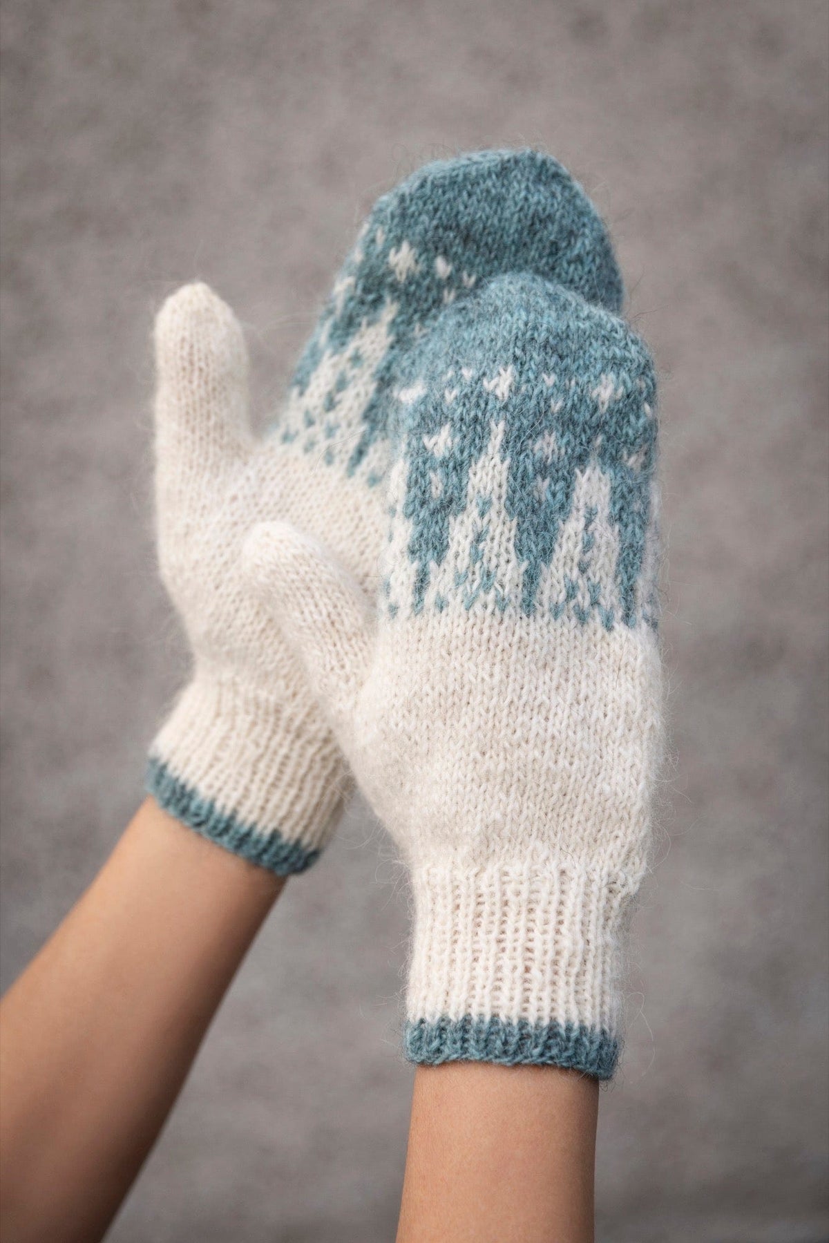 Snjóborg mittens knitted in Fjallalopi — lily white with a glacier sand pattern at the top and a ribbed cuff